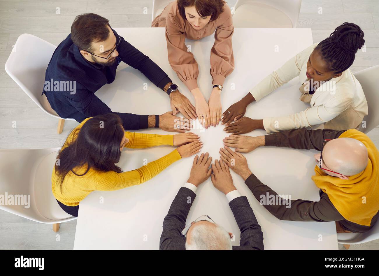 Diverse team of serious business people sitting around an office table during a work meeting Stock Photo