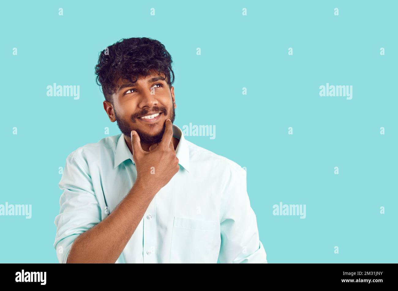 Joyful dreamy Indian man thinks and imagines something nice isolated on ...