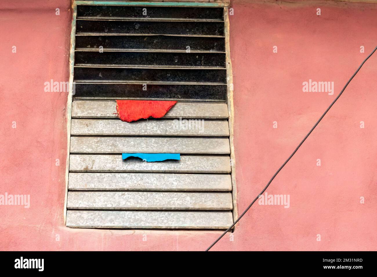 Two small pieces of cloth are drying in a lowcost metal window Stock