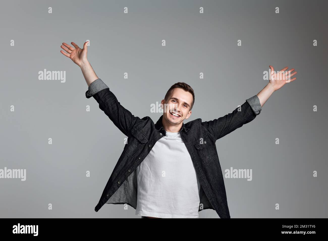 amazed man celebrating victory on gray background. Stock Photo