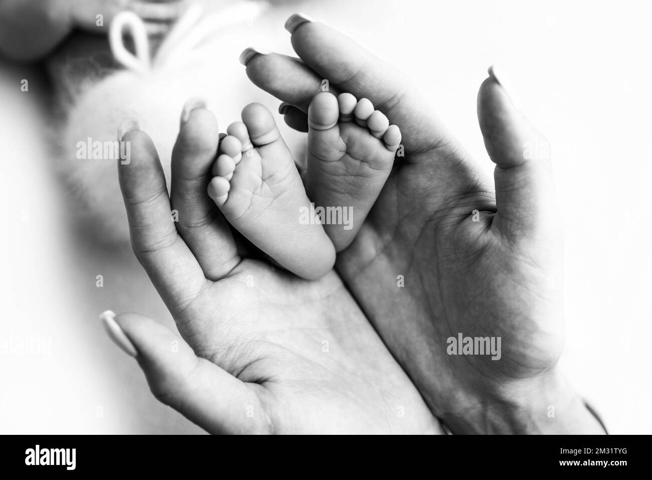 The palms of the parents. A mother hold a newborn baby by the legs