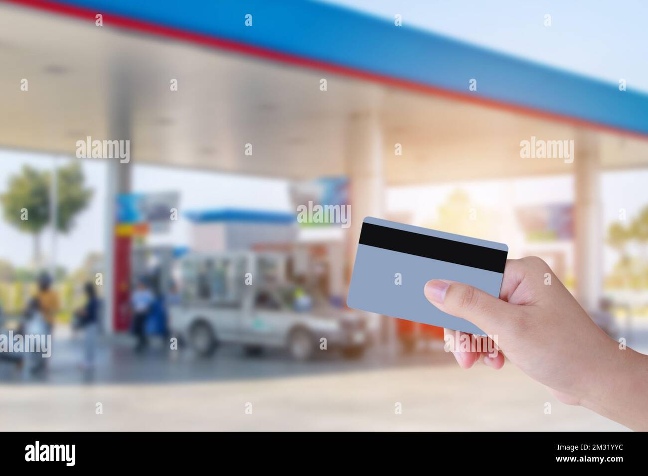 Hand hold credit card payment with gas station background Stock Photo