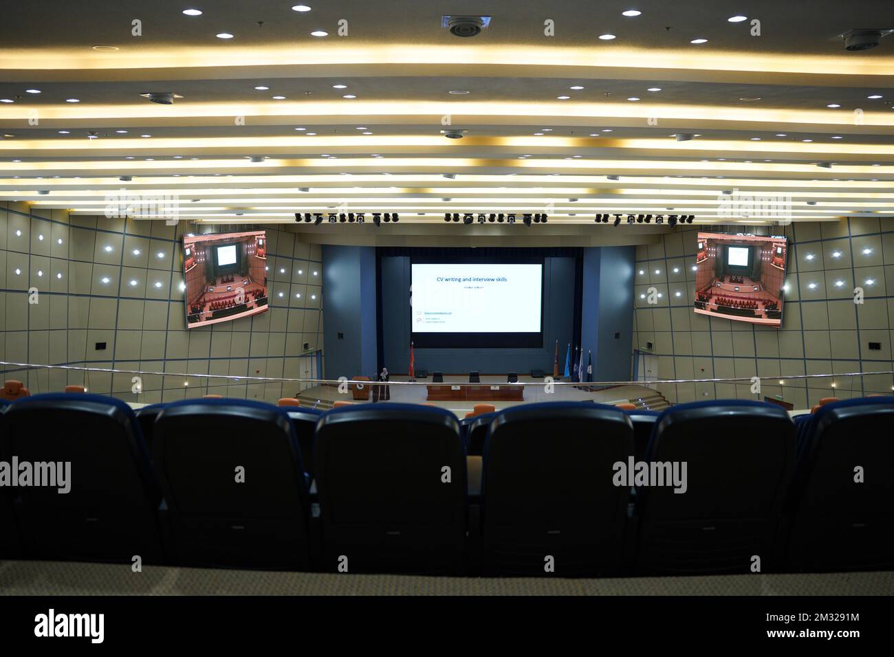 Huge and luxurious University auditorium chairs with presentation big screen. Blue theatre chairs. Stock Photo