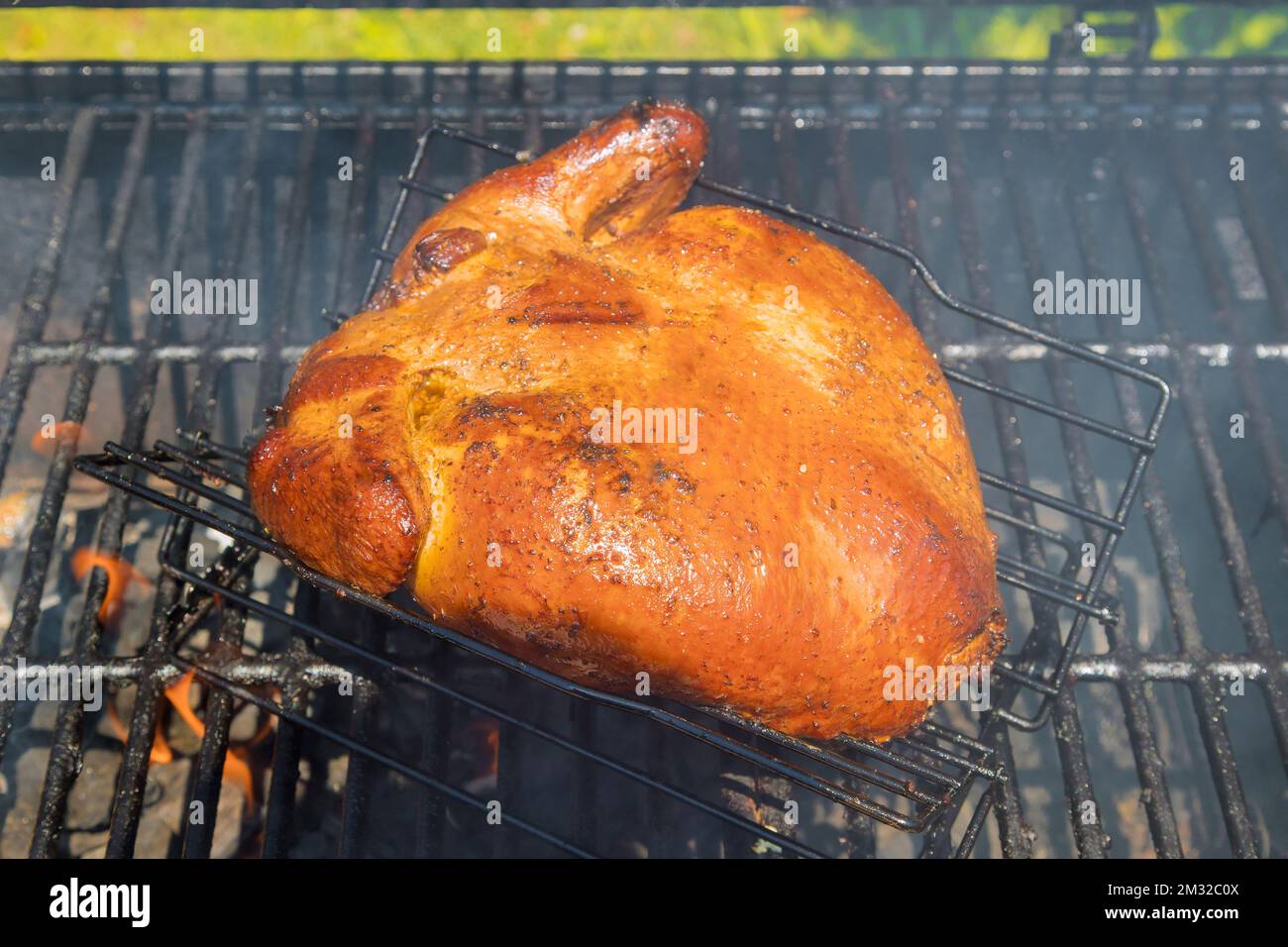 Traditional homemade roasted and smoked whole chicken on BBQ grill