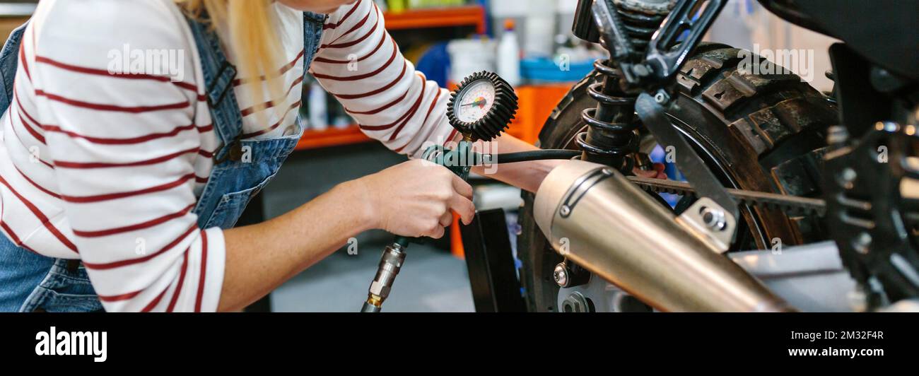 Mechanic woman checking tire air pressure of motorcycle Stock Photo Alamy