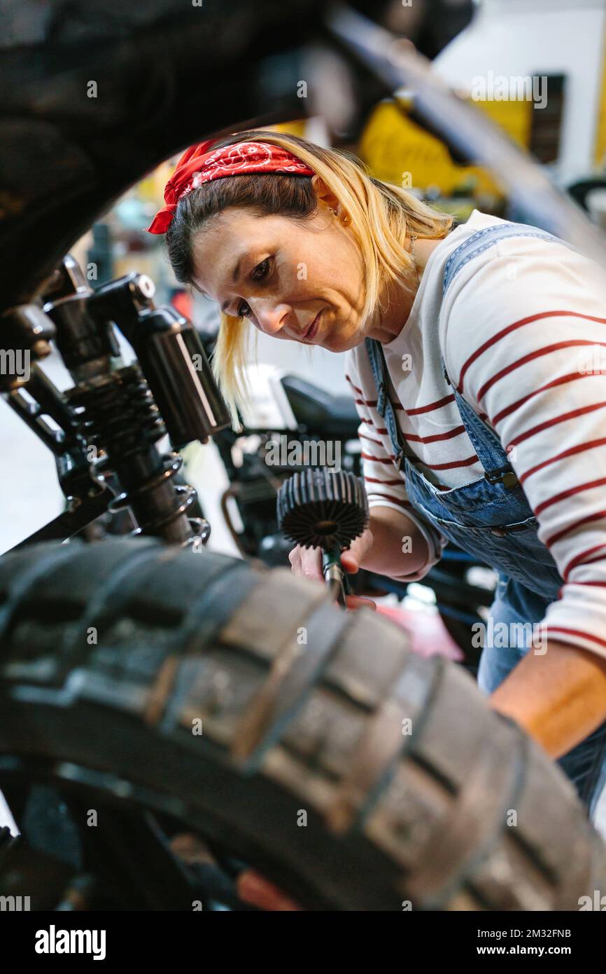 Mechanic woman checking tire air pressure of motorcycle Stock Photo Alamy