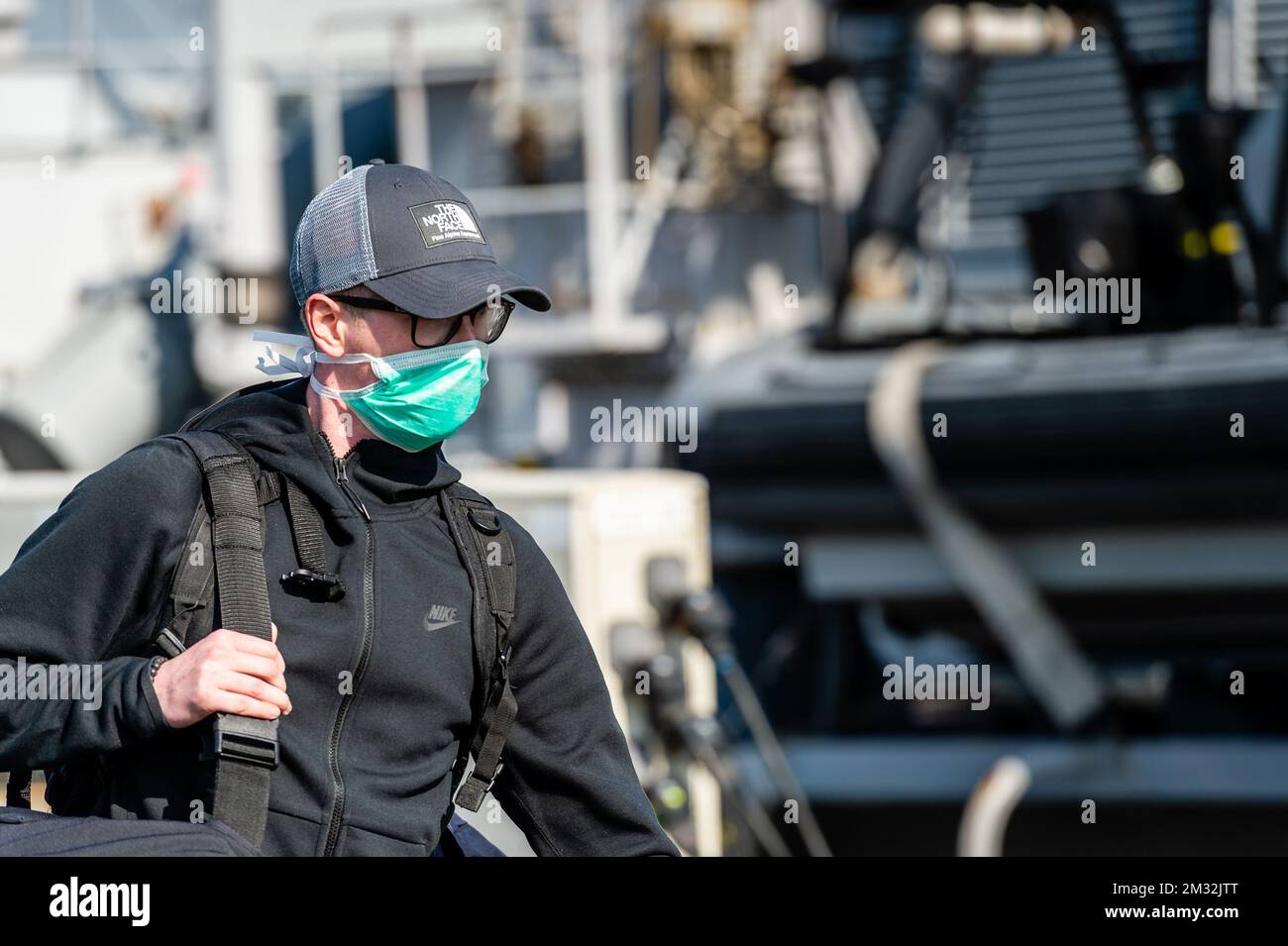 ATTENTION EDITORS - HAND OUT PICTURES - EDITORIAL USE ONLY - MANDATORY CREDIT HANDOUT DEFENSIE - DEFENCE TBN JORN URBAIN a person wearing a mouth mask pictured at the arrival of Belgian frigate Leopold 1 in Zeebrugge, Friday 27 March 2020. One of the sailors on the frigate has a confirmed Corona virus infection and has left the ship earlier. Due to the strict measures following such an infection, the ship has returned earlier from its mission and all non-infected sailors must now stay in home quarantine. BELGA PHOTO HANDOUT DEFENSIE - DEFENCE TBN JORN URBAIN  Stock Photo