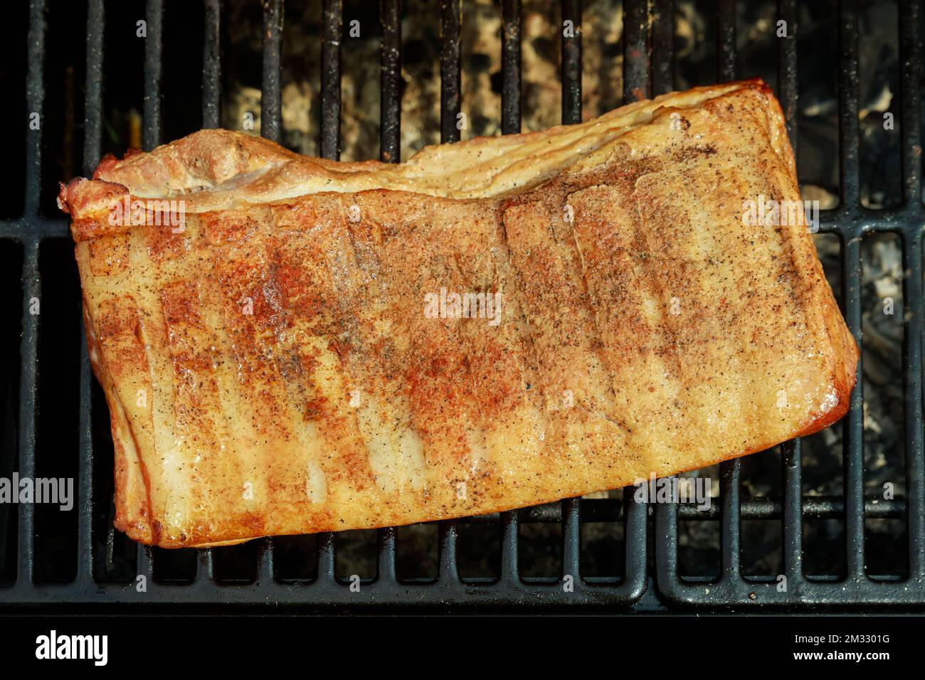 Roasted smoked whole bacon cooked on BBQ grill in traditional way Stock Photo