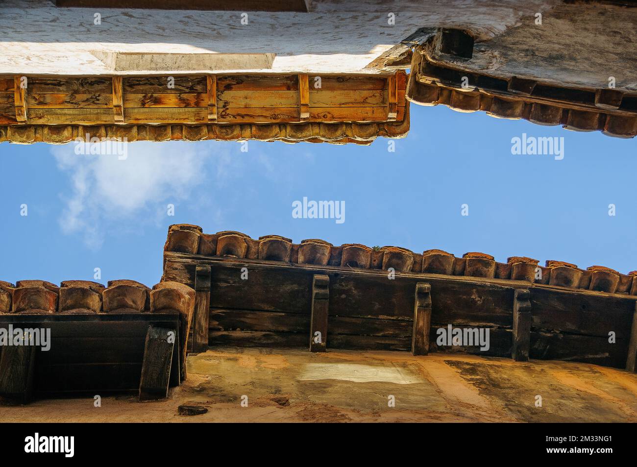 A low angle shot of old wooden roofs of a building under the blue sky ...