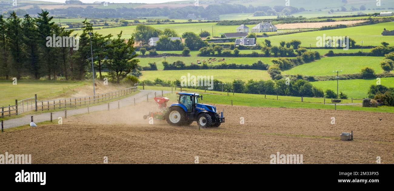 County Cork, Ireland, August 20, 2022. A blue tractor sows a plowed
