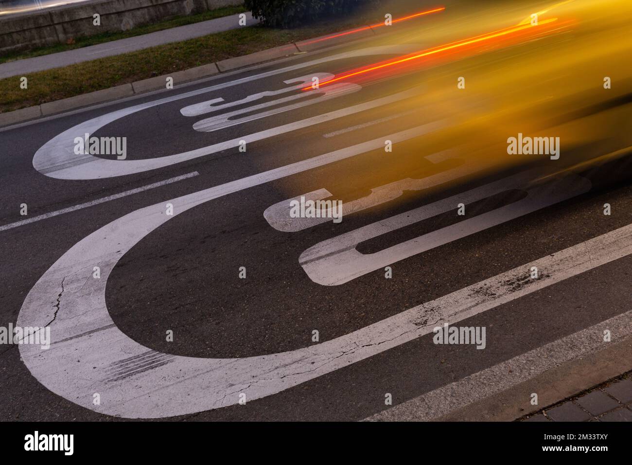 Acceleration of vehicle on speed limit sign. Image in movement, burst of light, wake of car. Stock Photo