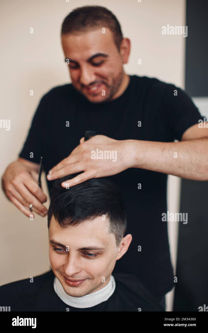hairdresser does haircut for man in barber shop Stock Photo - Alamy