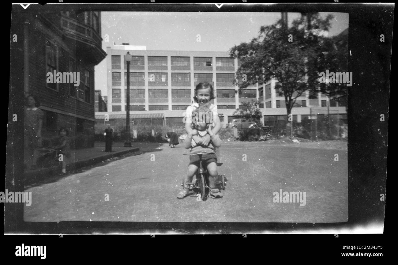A girl hugs another child on a tricycle , Children, Bicycles