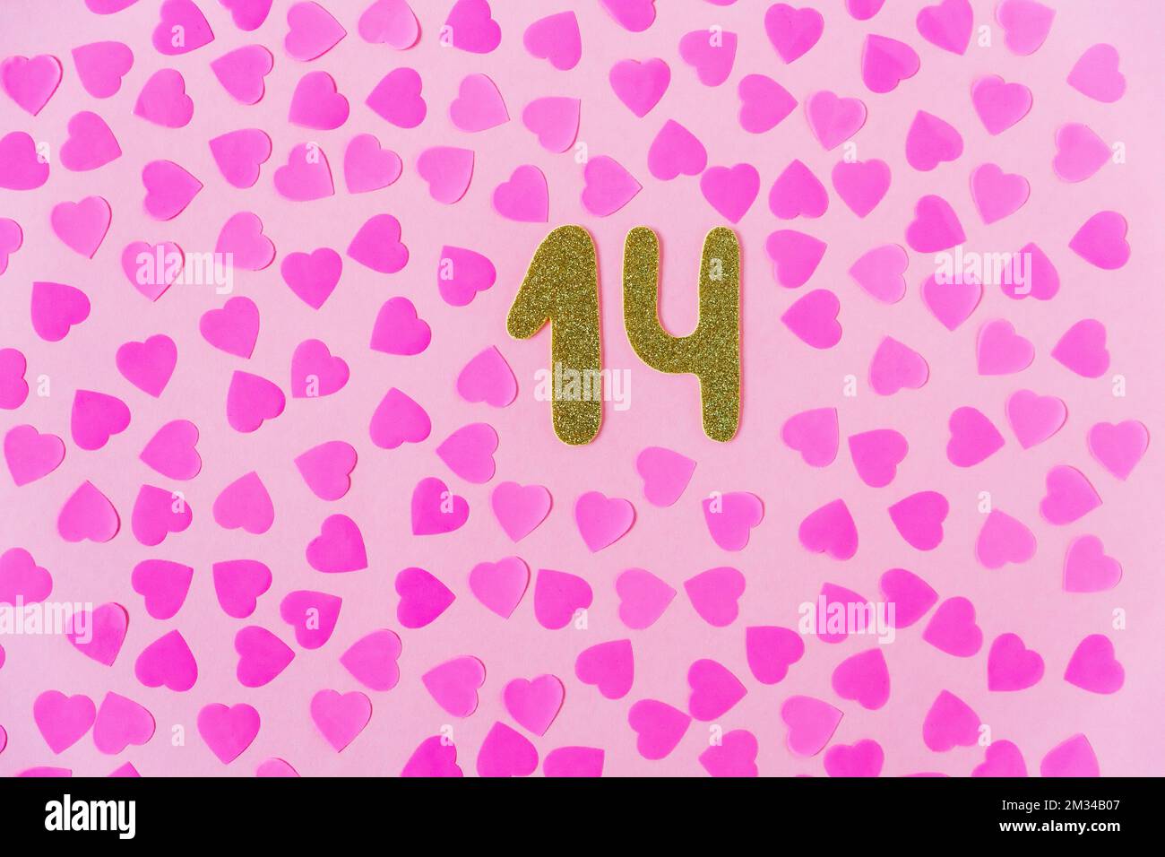 Valentines day composition. Pink background with sparkl gold numbers 14