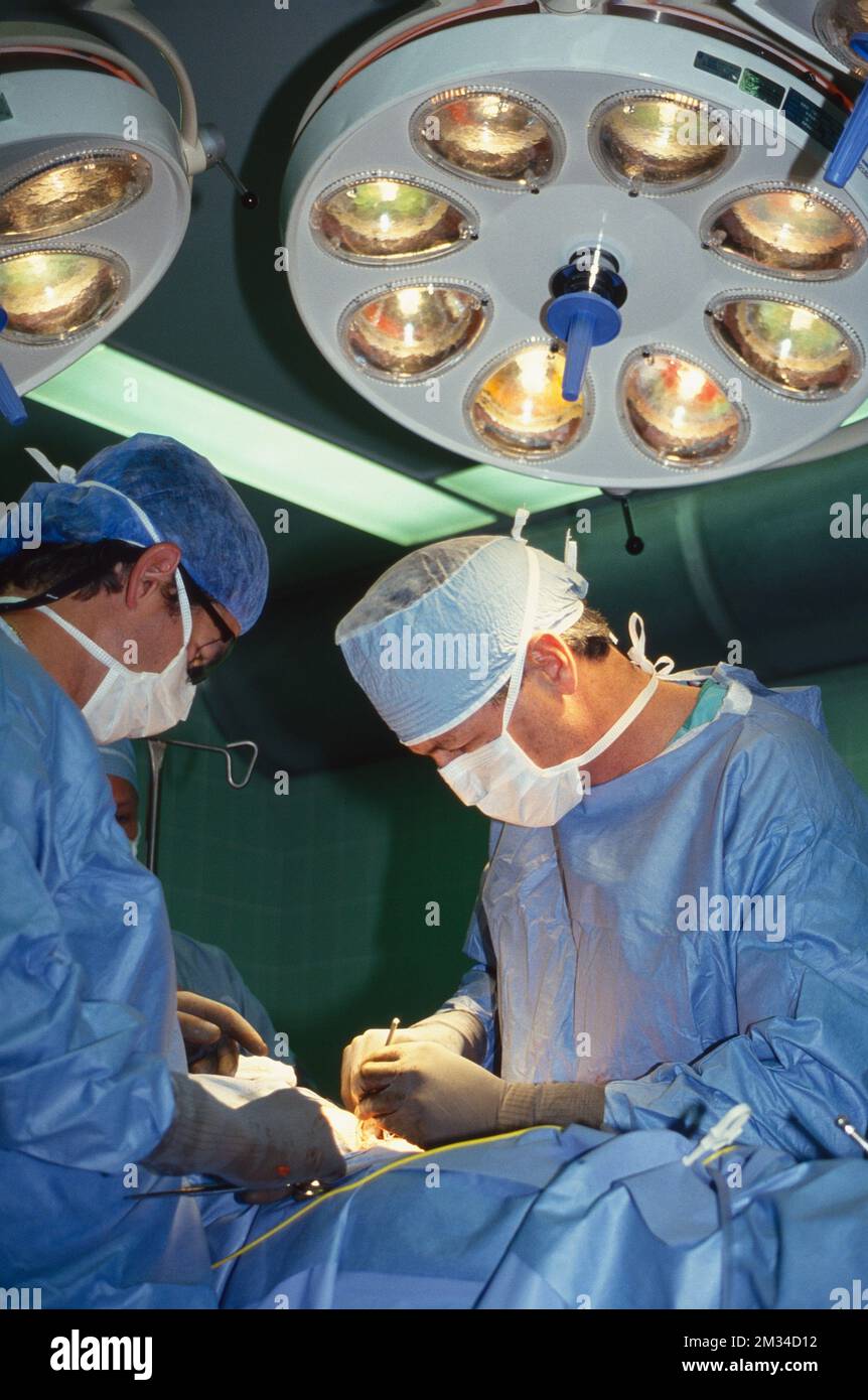 Doctors perform surgery under lights in operating room Stock Photo - Alamy