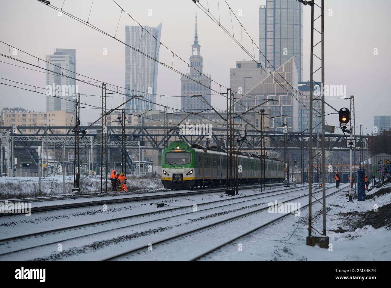 Warsaw, Warsaw, Poland. 14th Dec, 2022. A train pass by workers as they work on December 14, 2022 in Warsaw, Poland. Polish State Railways (PKP) signed an agreement with the Center for European Union Transport Projects (CEUTP) and will receive a 1.3 billion of Polish Zlotys of co-financing for the modernisation of the central part of the main train line artery that cuts through Warsaw. The modernisation is part of the EU project TEN-T (Credit Image: © Aleksander Kalka/ZUMA Press Wire) Stock Photo