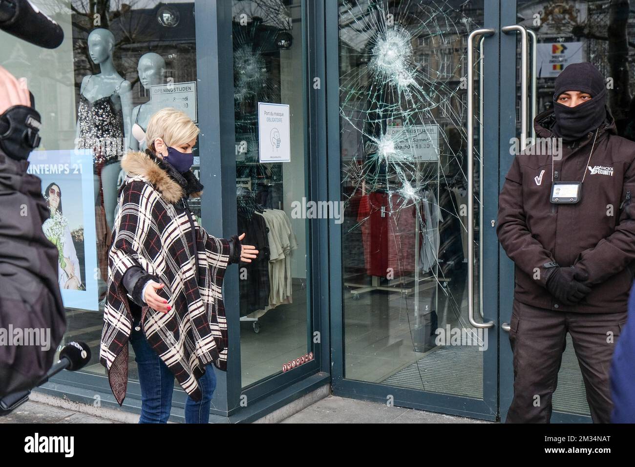 Illustration picture shows a security guard in front of the broken doors of a shop, in the aftermath of the riots in the city center of Liege, Sunday 14 March 2021. Some 200 people who were demonstrating as part of the 'Black lives matter' action on Saturday afternoon, attacked the Liege police in various places in the city center and a fast food restaurant was ransacked. Several policemen were injured. BELGA PHOTO BRUNO FAHY Stock Photo