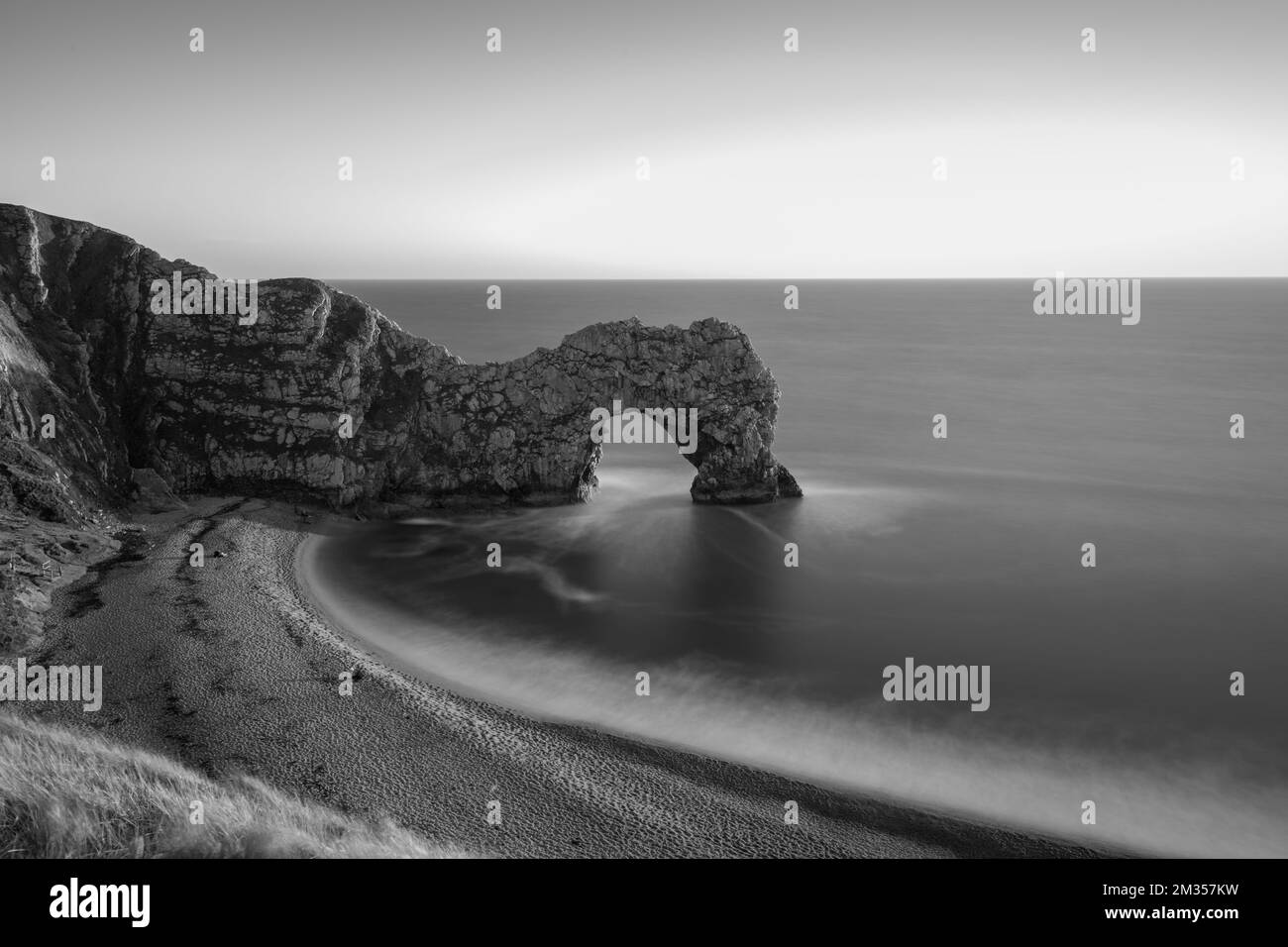 Long exposure of the calm sea at Durdle Door at dusk Stock Photo