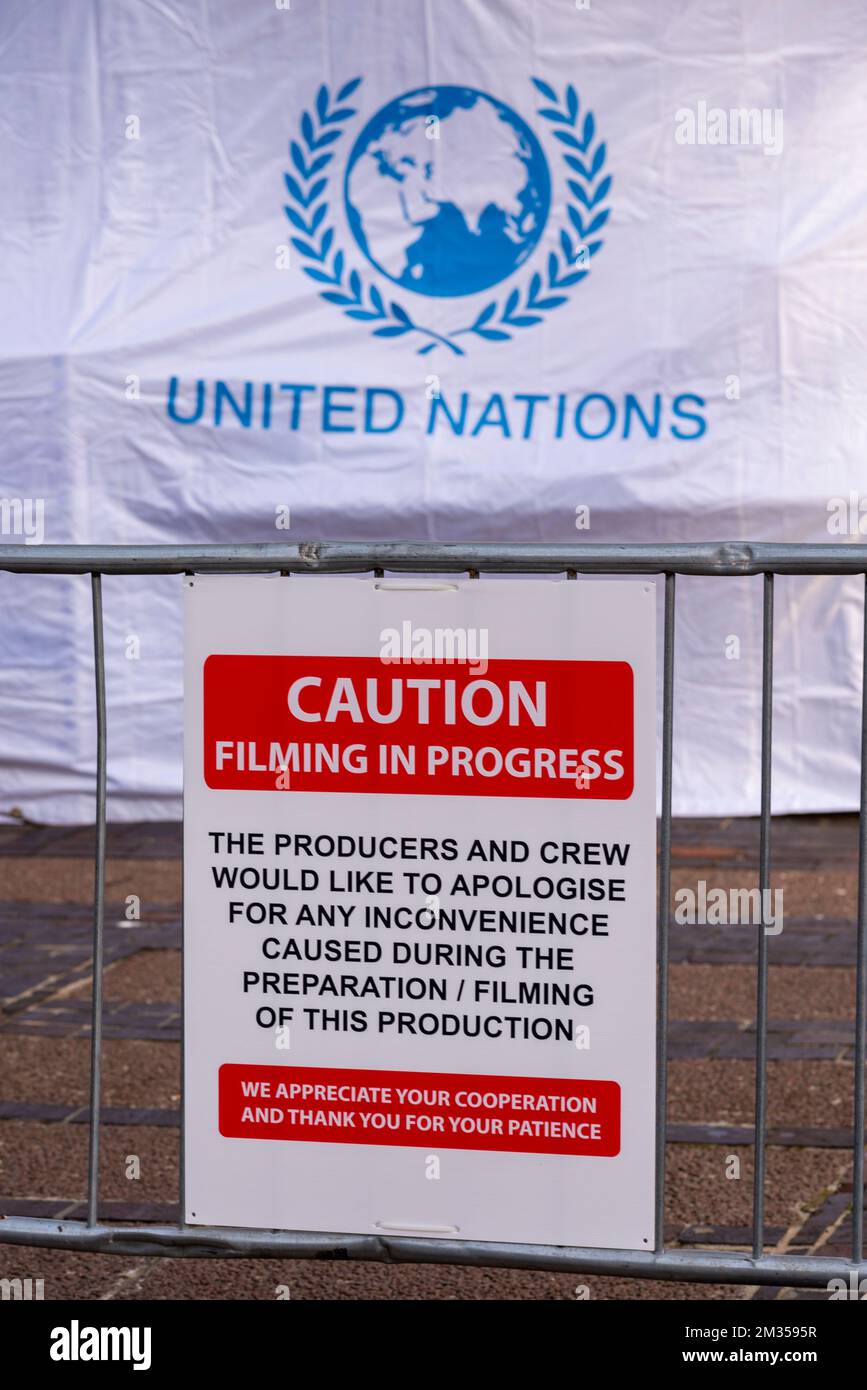 Caution sign during filming for series 6 of Netflix The Crown on location in Southend on Sea, Essex, UK. Kosovo film set with United Nations tent Stock Photo