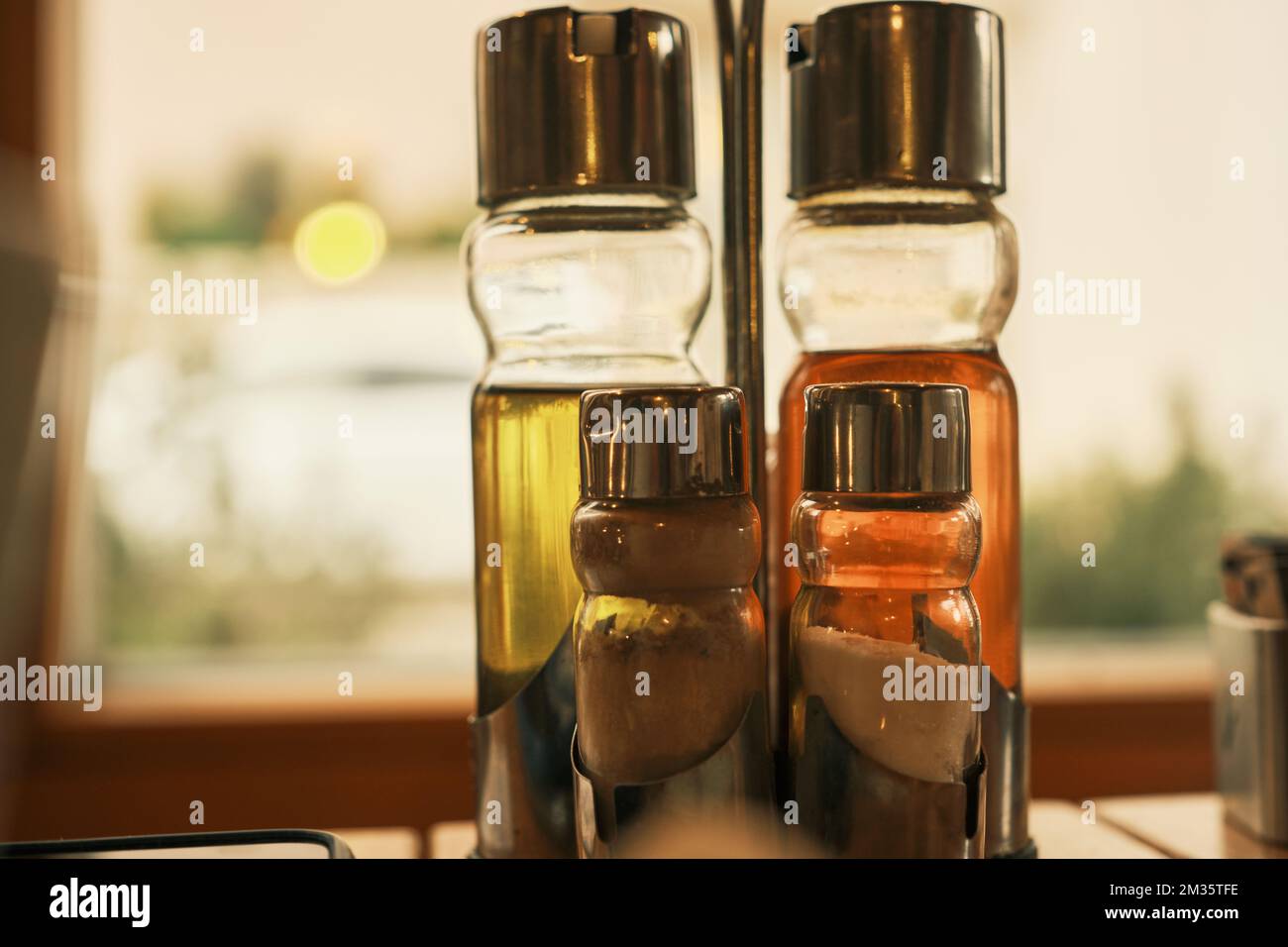 Two small bottles of butter on a summer café table Stock Photo