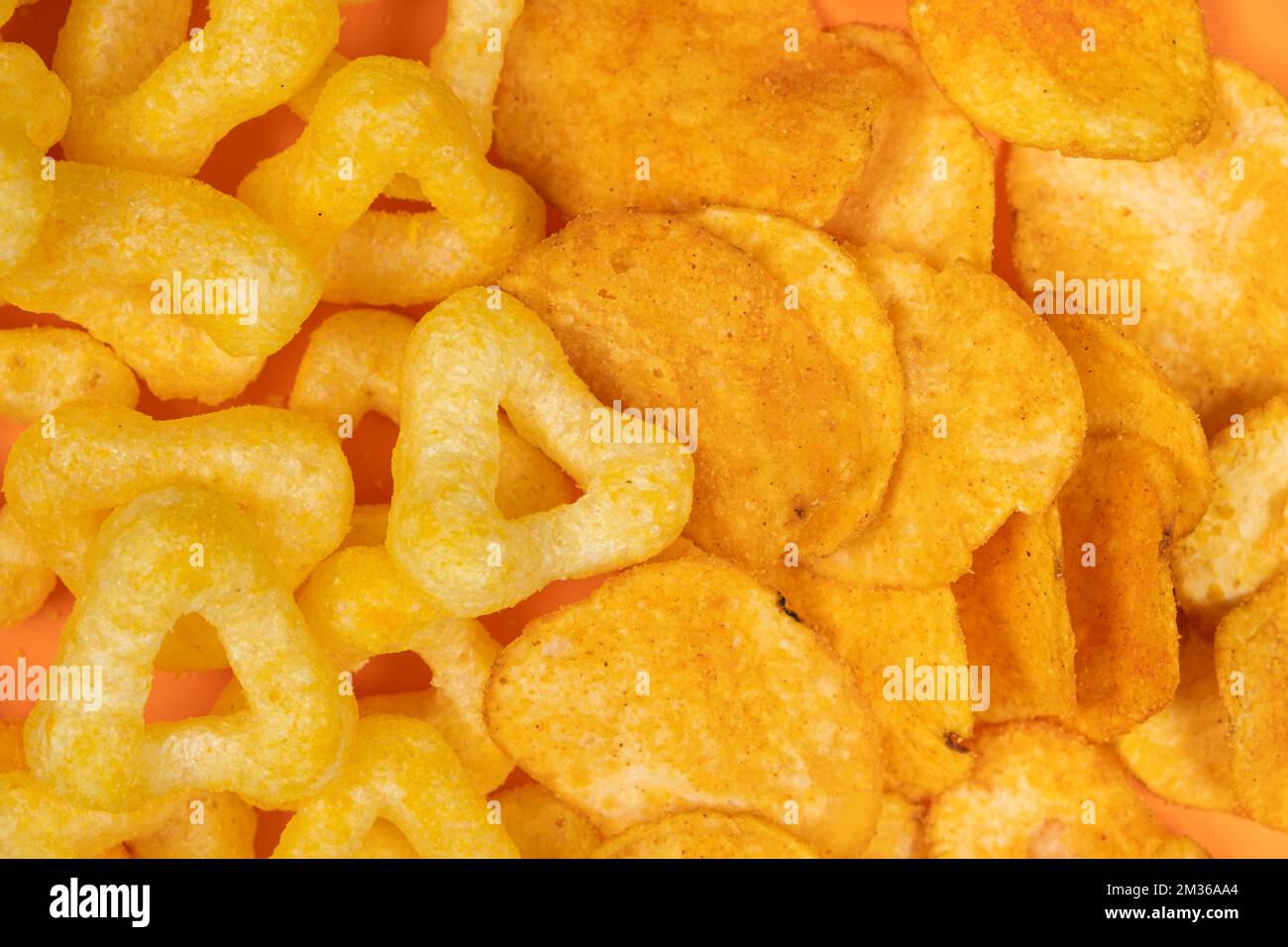 Crispy potato and corn chips, close-up view from above. Stock Photo