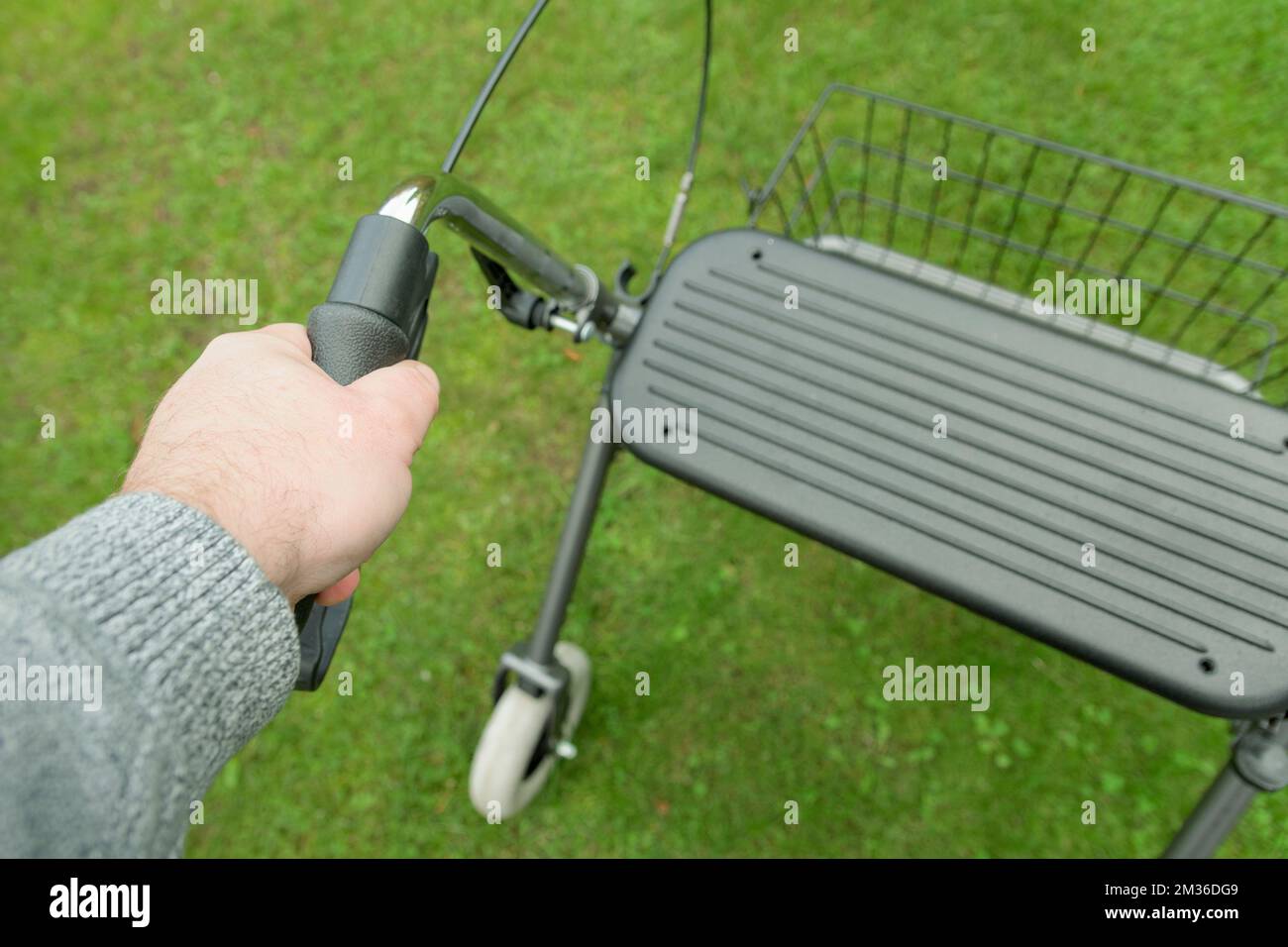 Using Walker Rollator outdoors. View from above. A man holding on to the left handle of a rollator Stock Photo