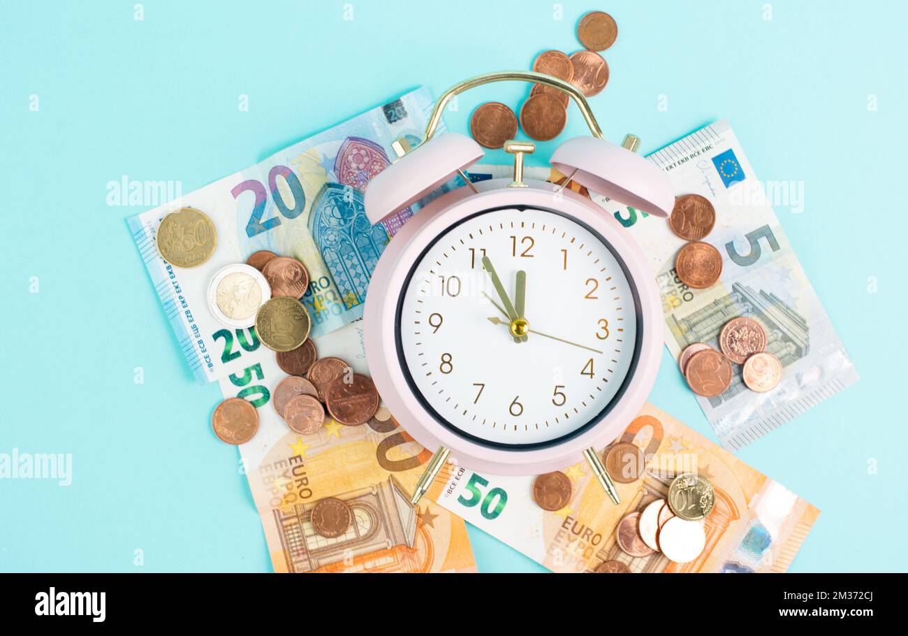 Clock Inflaon Alarm clock with Euro banknotes and coins, inflation, recession and ...