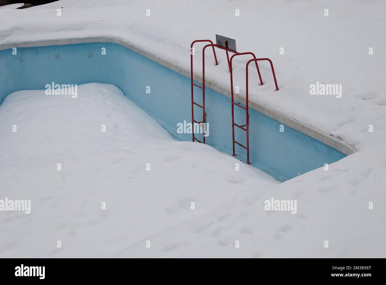 frozen swimming pool with boarding ladder Stock Photo