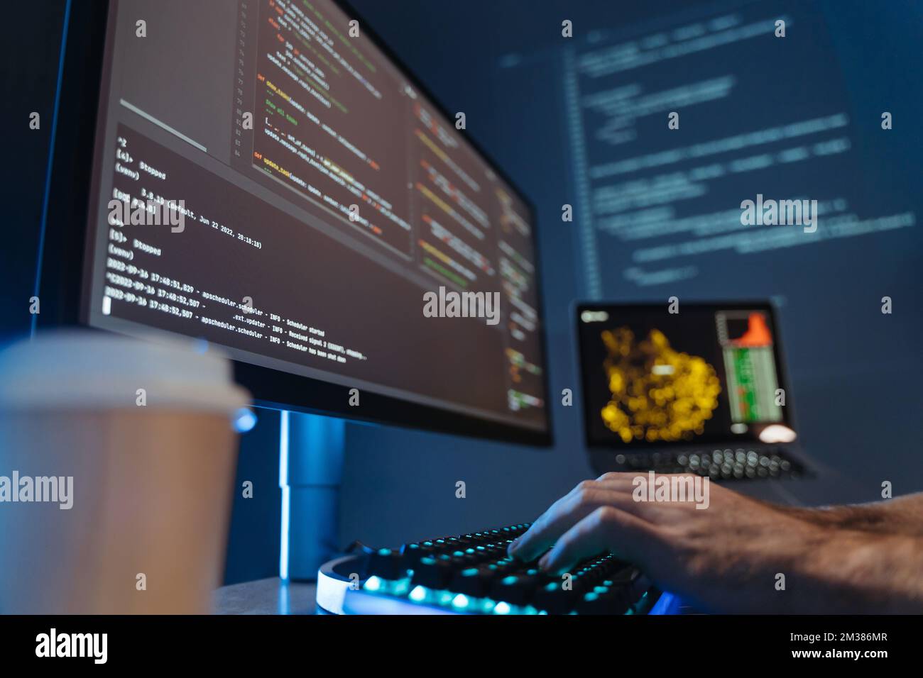 No face picture of male hands of software engineer sitting at table in front of big pc screen, typing and composing app script, working in data science company. Selective focus Stock Photo