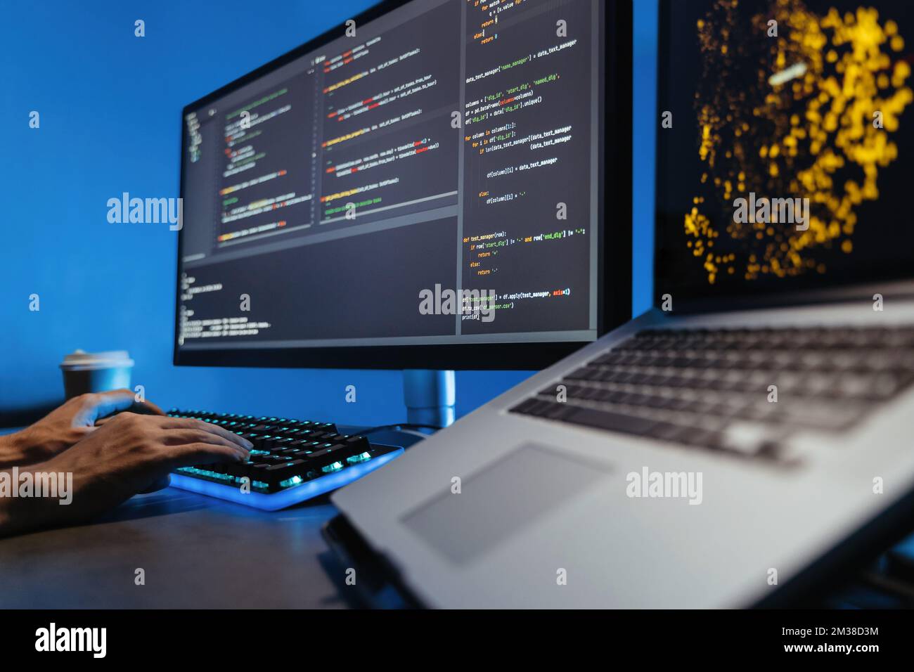 Data science concept. No face image of male hands typing on keyboard, writing html code for website, sitting at desk with pc and laptop, working on project in software development company Stock Photo