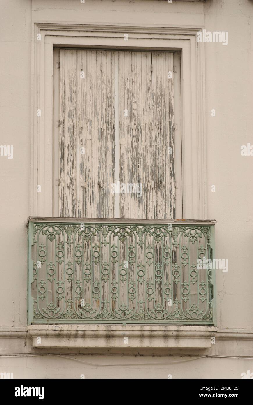 weathered old window with closed shutter and railing Stock Photo