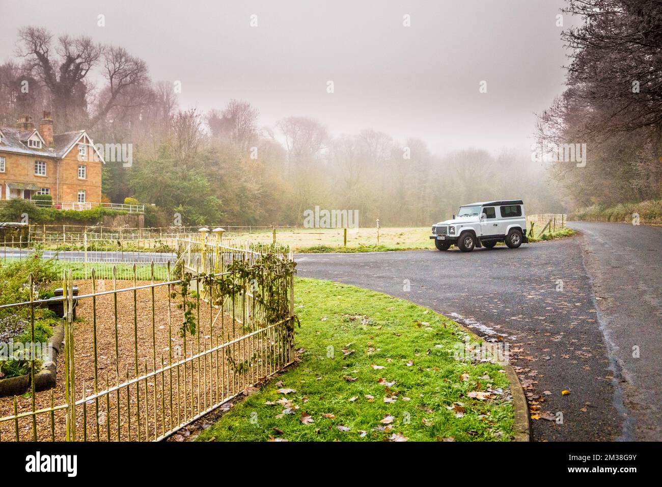 Parked white Landrover Defender 90 county model on a quite country lane on a cold and frosty day. Stock Photo