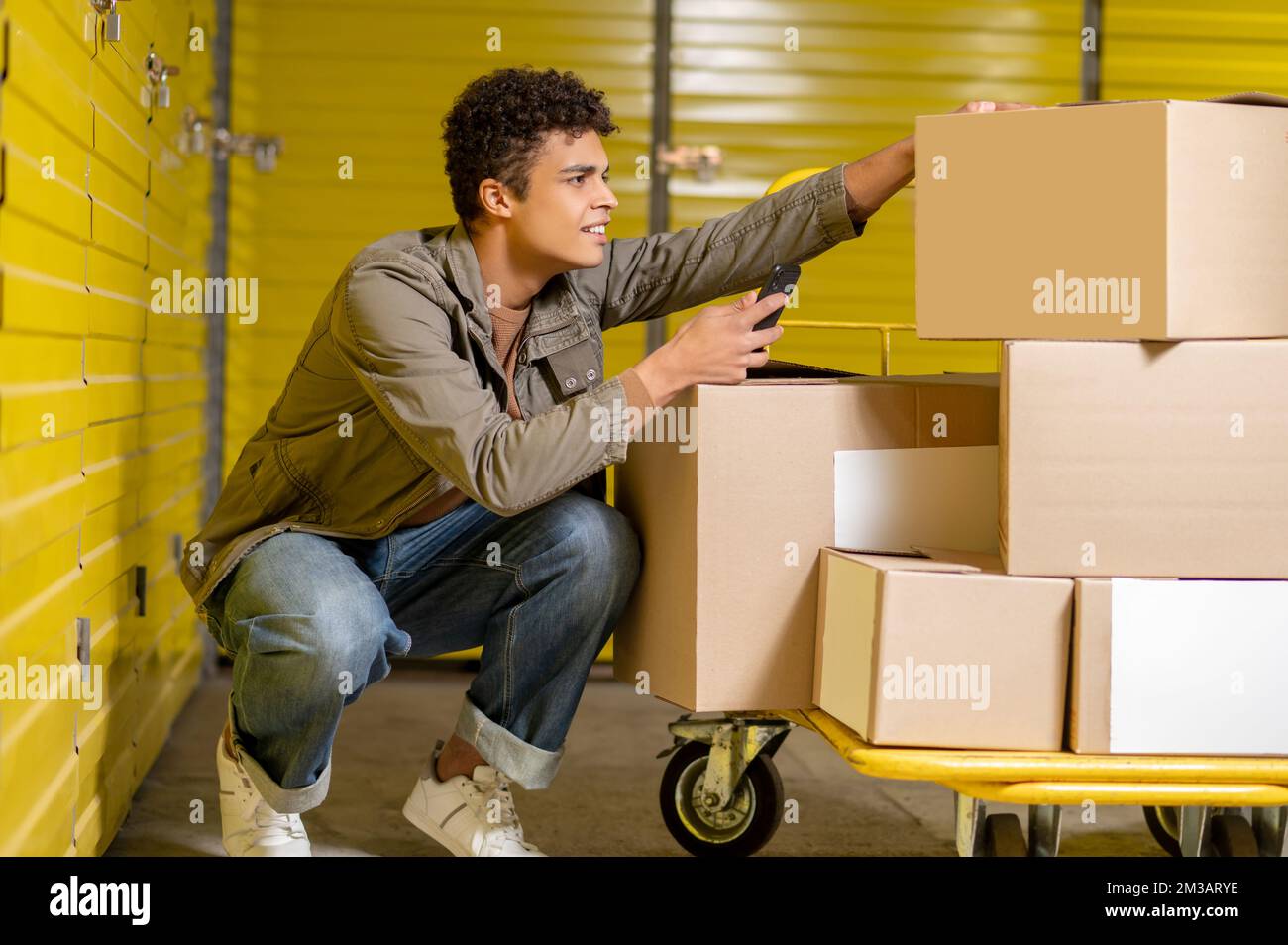 Service Man Images Curly-haired young service man making picture of the boxes Stock Photo ...