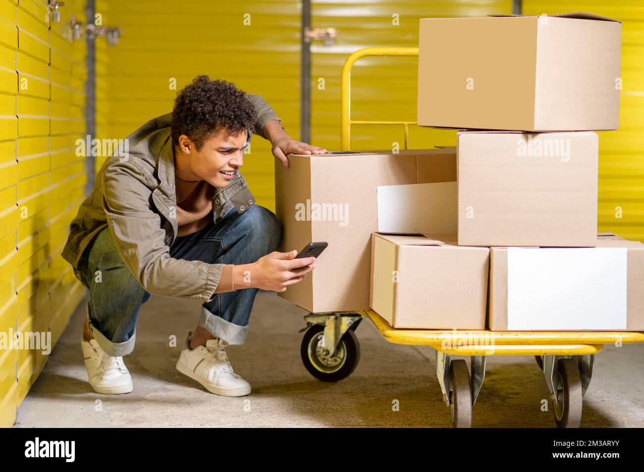 Service Man Images Curly-haired young service man making picture of the boxes Stock Photo ...