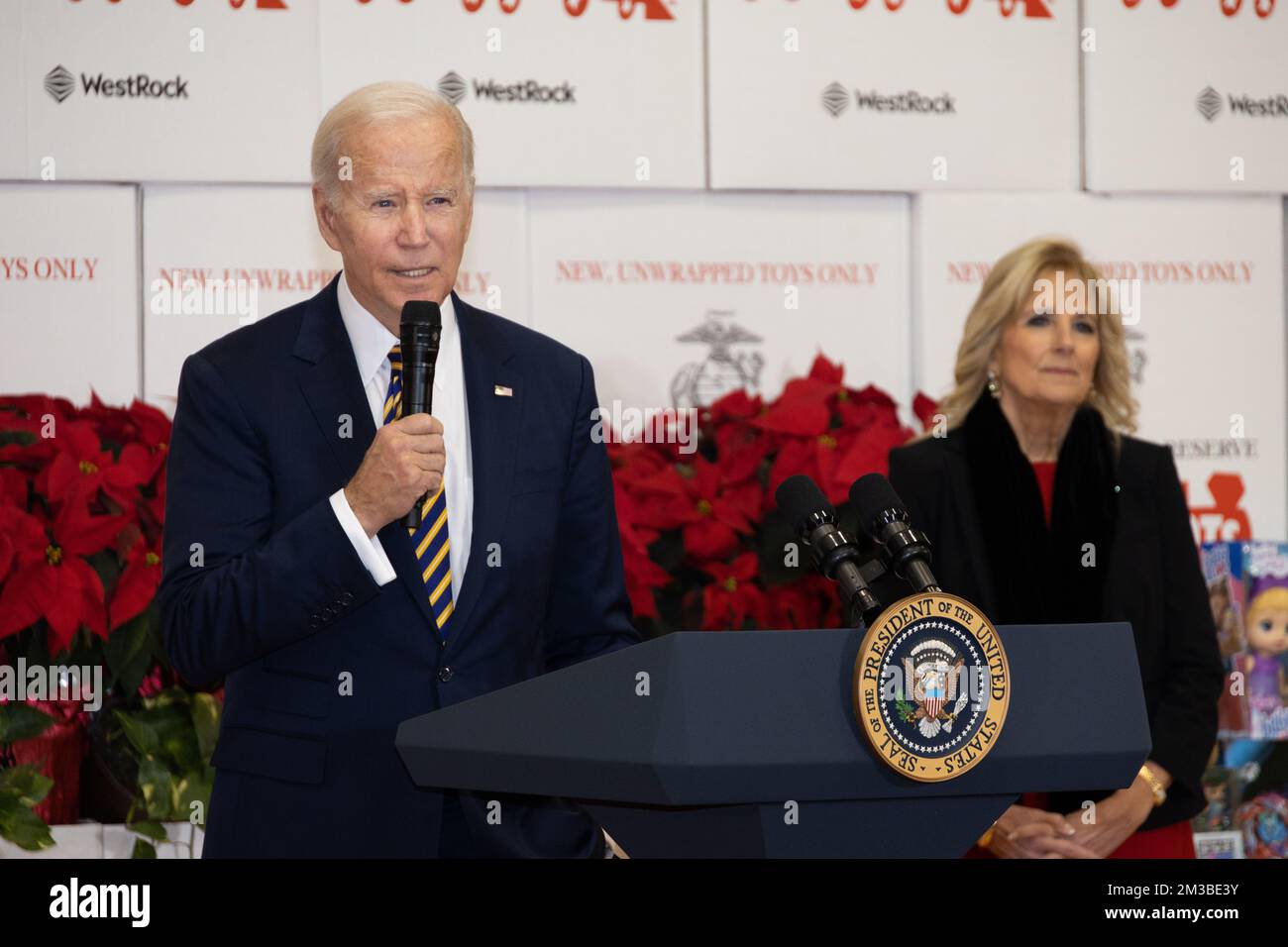 Arlington, United States. 12 December, 2022. U.S. President Joe Biden delivers remarks as First Lady Jill Biden, right, looks on during the 75th anniversary Toys for Tots sorting at Joint Base Myer-Henderson Hall, December 12, 2022 in Arlington, Virginia.  Credit: Sgt. Ellen Schaaf/US Marine Corps/Alamy Live News Stock Photo