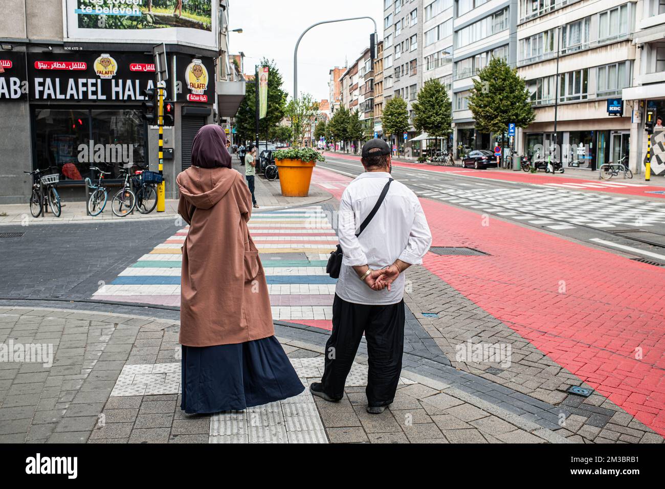 Illustration picture shows a muslim couple waiting to cross a rainbow zebra crossing on the Turnhoutsebaan in the centre of Borgerhout, one of the districts of the city of Antwerp, Monday 15 August 2022. This year, there have been several attacks and explosions in the streets of Borgerhout, possibly with links to drugs crimes. BELGA PHOTO JONAS ROOSENS Stock Photo