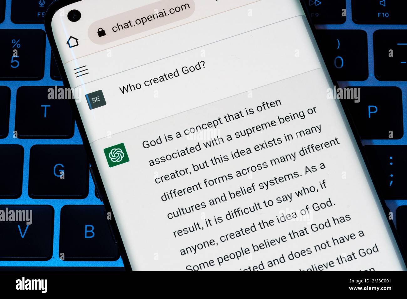 OPEN AI ChatGPT chat bot seen on smartphone placed on laptop. AI chatbot responded to the question about creation of God. Stafford, United Kingdom, De Stock Photo