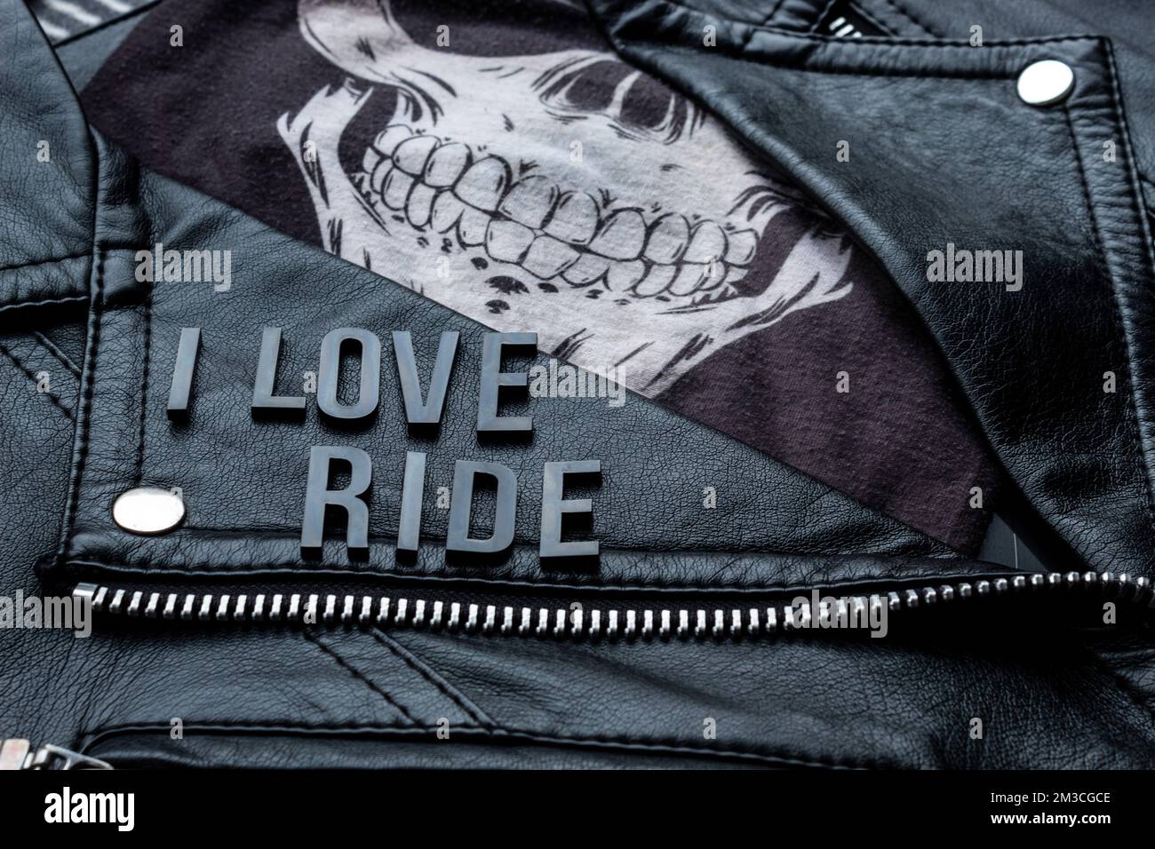 closeup to I love ride lettering over biker leather jacket and skull ...