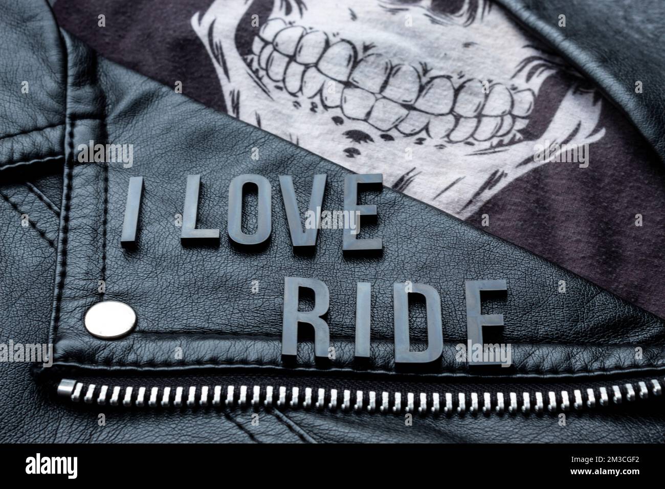 closeup to I love ride lettering over biker leather jacket and skull ...