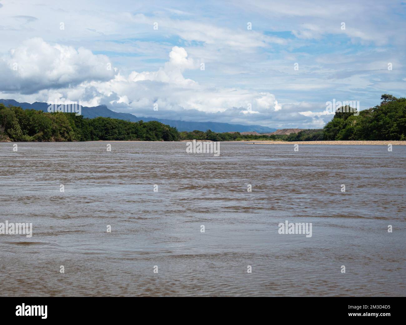 Magdalena River Landscape in sunny day with sand banks, green trees and bushes, clouds and blue sky at background near to Aipe town, Huila Colombia Stock Photo