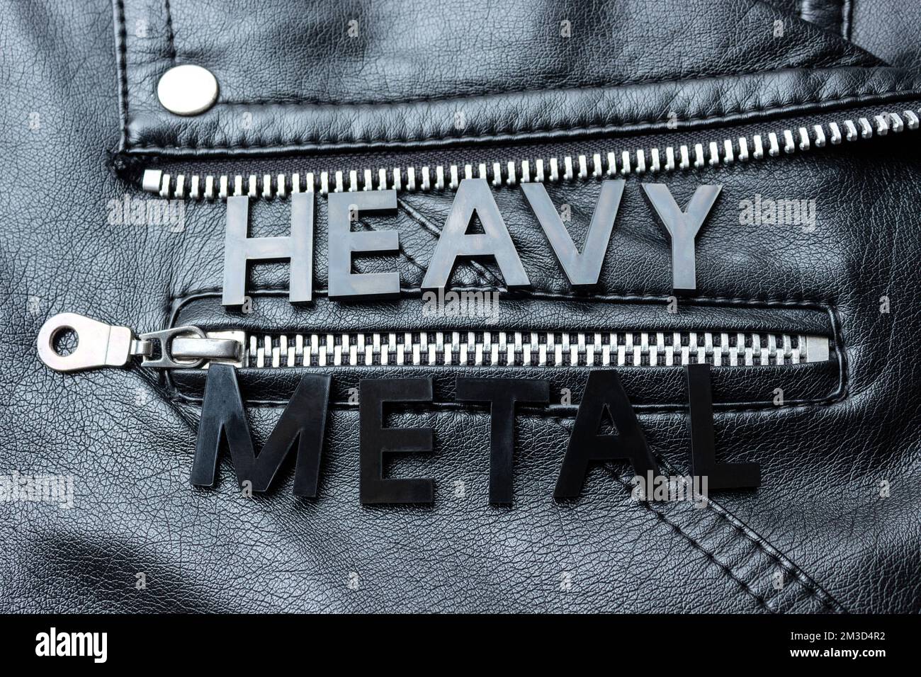 Closeup to a HEAVY METAL black lettering word over a black biker leather jacket. Heavy metal music lovers and fashion concept style Stock Photo