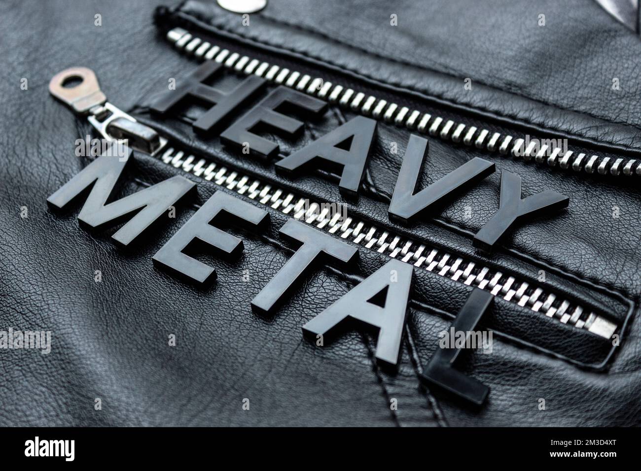 Closeup to a HEAVY METAL black lettering word over a black biker leather jacket. Heavy metal music lovers and fashion concept style Stock Photo