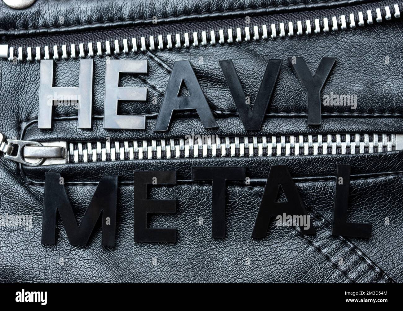 Closeup to a HEAVY METAL black lettering word over a black biker leather jacket. Heavy metal music lovers and fashion concept style Stock Photo