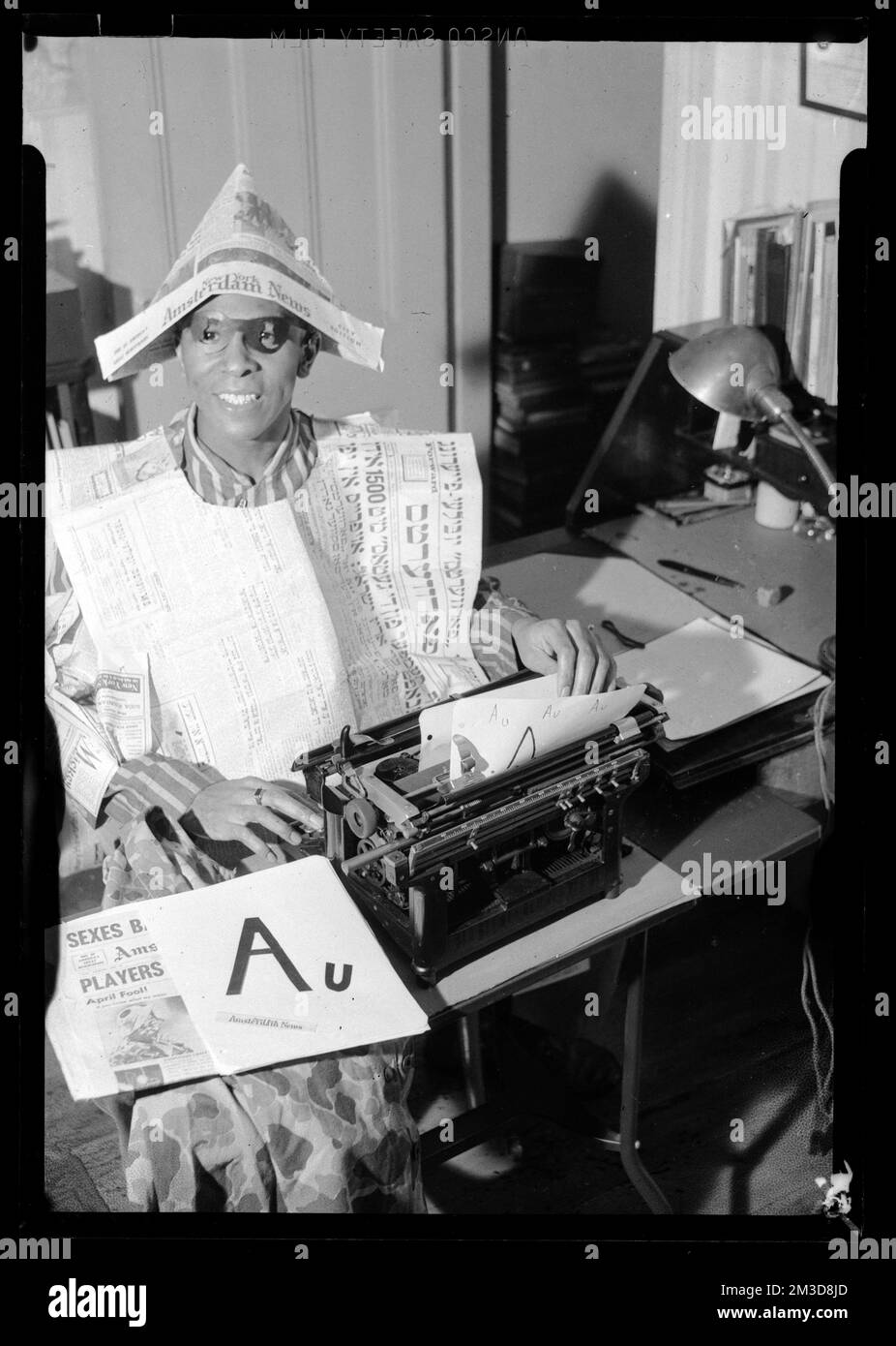 Jack Miller sits at typewriter wearing costume made of newspaper
