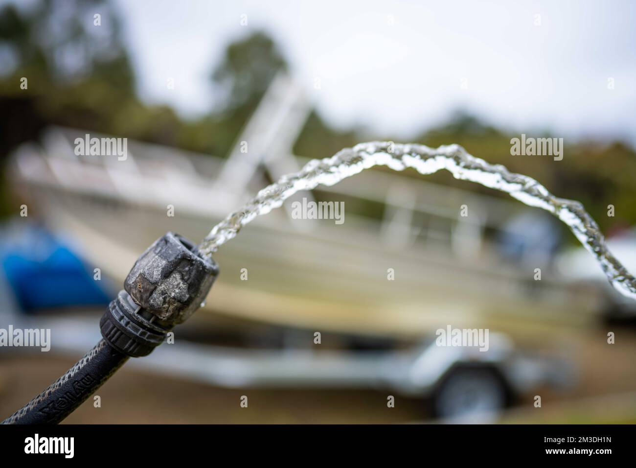 filling up water tank of caravan while camping. washing car and boat in