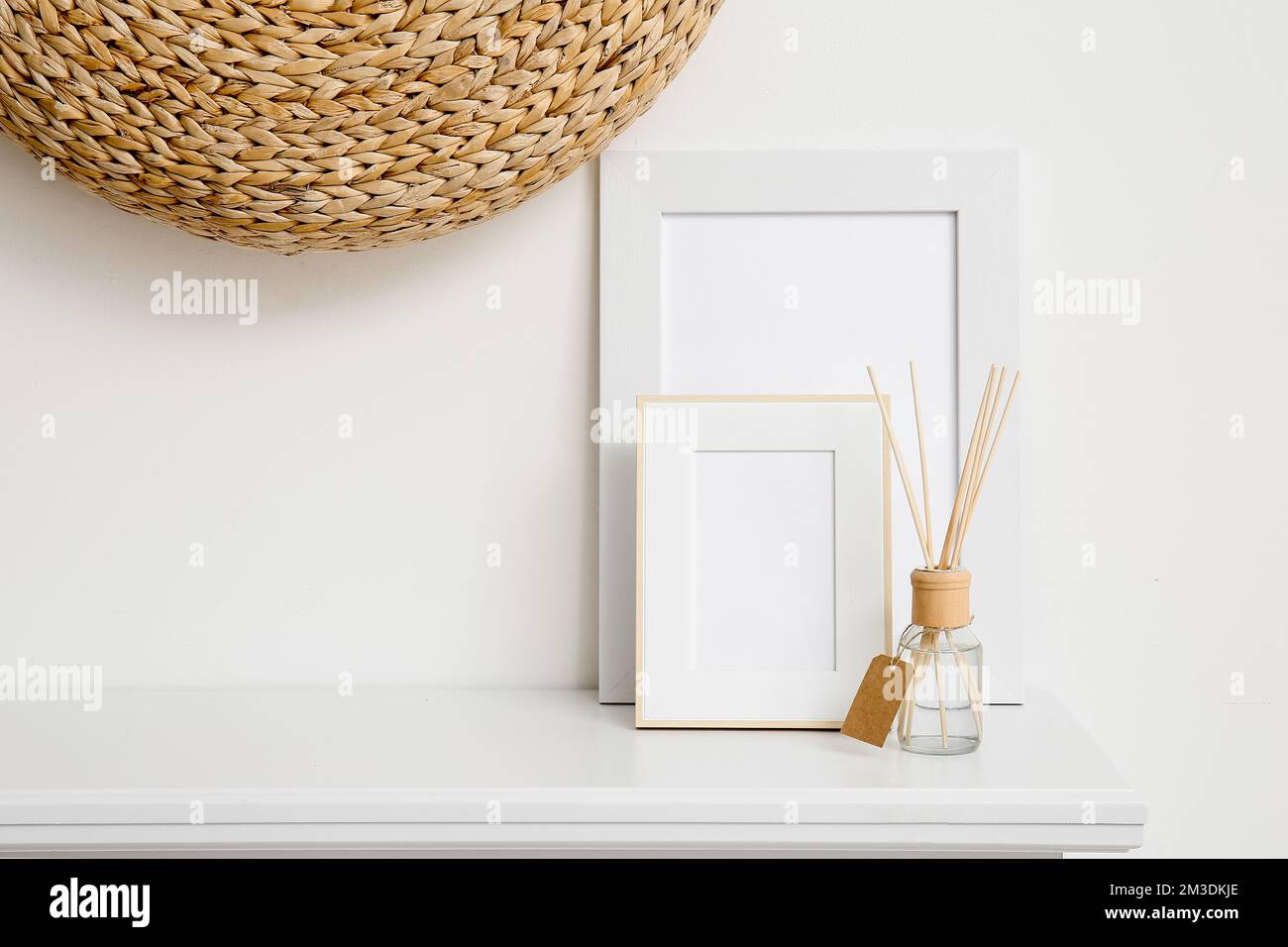 Blank photo frames and reed diffuser on shelf near white wall Stock ...