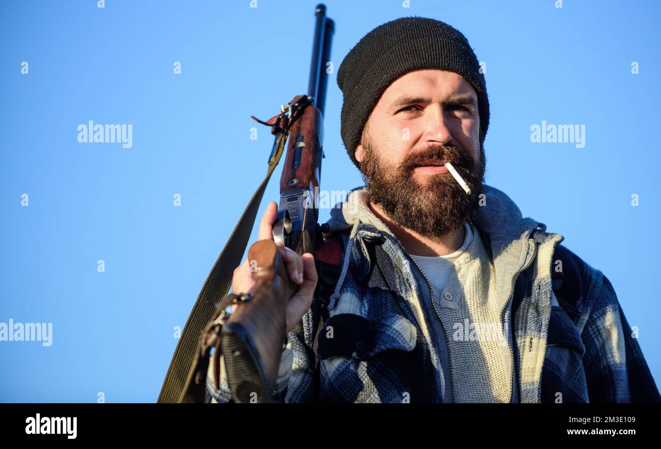 Man brutal bearded guy gamekeeper blue sky background. Brutality and
