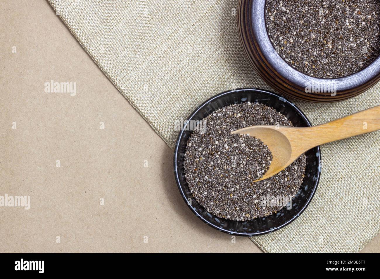 Healthy breakfast, Chia seeds with spoon in black bowls on linen cloth ...