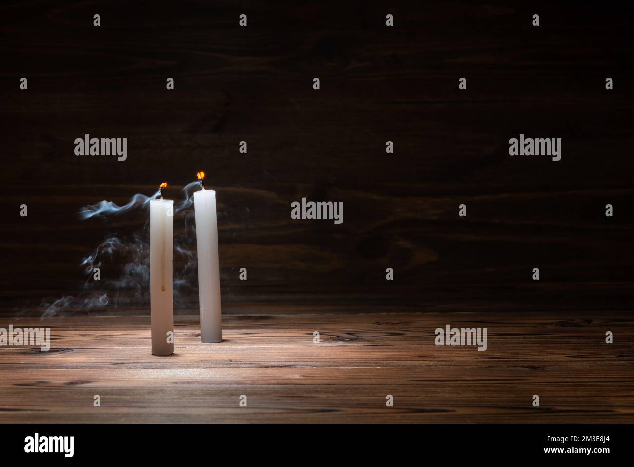 two extinct candles on wooden background in minimalist room interior with copy space, concept Stock Photo