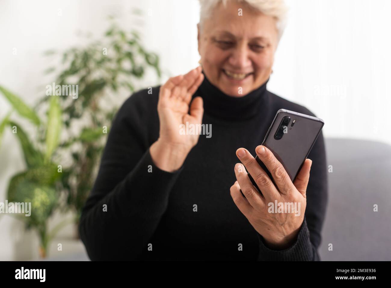 Happy mature old 60s woman holding smartphone using mobile phone app for video call laughing while watching funny video feeling excited winning Stock Photo Alamy